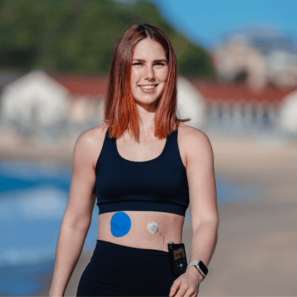 Emma walking on the beach with her Type Strong Medtronic Guardian patch and Type Strong Pump Infusion Set patch